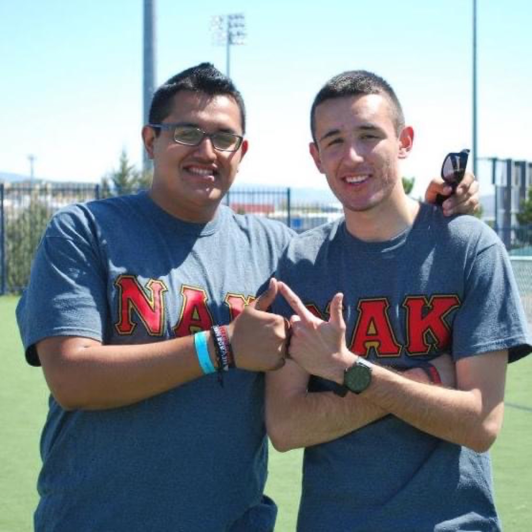 Two brothers throwing the NAK sign on campus